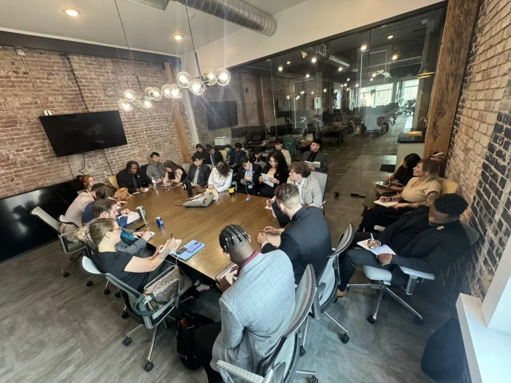 A full team meeting in the Crescent brick-walled office